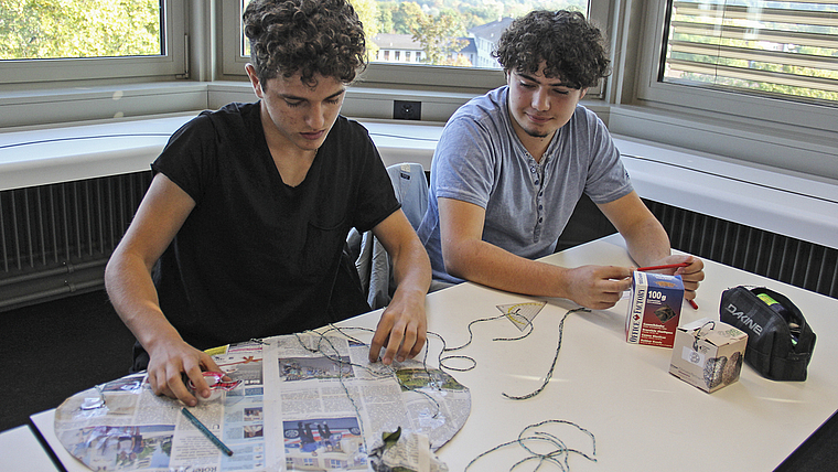 Konstruktionsphase: Valerio Job und Axel Carroll (rechts) bauen ihren Fallschirm «Schleudersitz 2000».  Foto: Tobias Gfeller