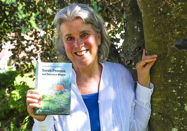 Lokal verbunden: Die Autorin und Journalistin Priska M. Thomas Braun mit dem neuen Buch unter ihrer geliebten Blutbuche.  Foto: Thomas Brunnschweiler