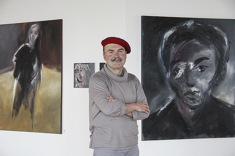 Maler und Werk: Sascha Dejanovic inmitten seiner Bilder. Foto: Tobias Gfeller