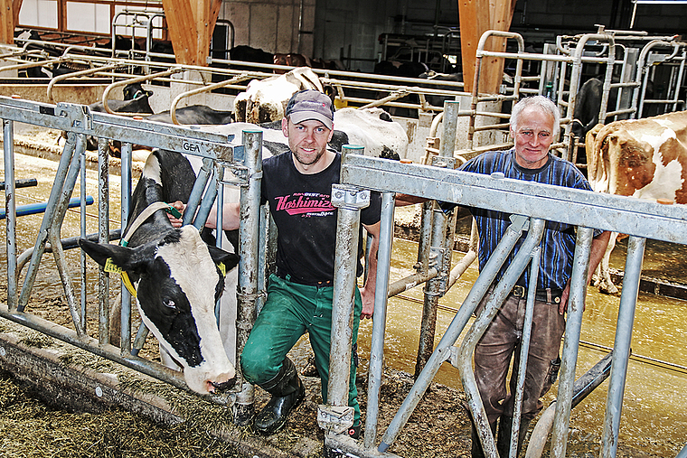 Die beiden Bauern der Betriebsgemeinschaft Langackerhof: Thomas Vögtli (r.) und Seppi Vögtli mit Kuh Lindsey. Foto: Benildis Bentolila.