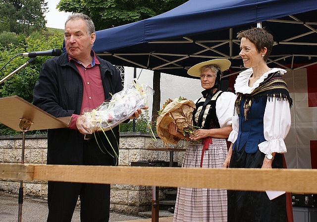 Kleine Aufmerksamkeit: Gemeindepräsident Theo Henz beschenkt Rednerin Sabine Asprion. Fotos: Jürg Jeanloz 
