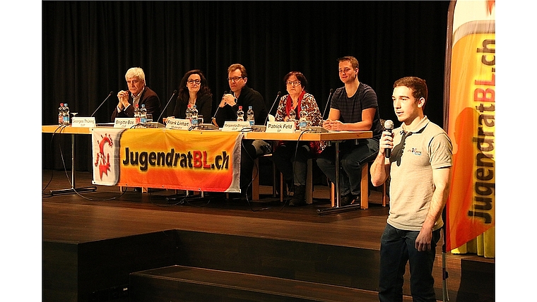 Podium: Fabian Schnell vom Jugendrat Baselland (r.) stellt die Podiumsteilnehmenden vor: (v.l.) Georges Thüring (SVP), Brigitte Bos (CVP), Moderator Frank Linhart, Margareta Bringold (GLP) und Patrick Feld (SP/JUSO). Foto: Gaby Walther