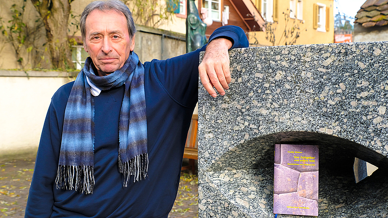 Ortsverbunden: Freddy Widmer und sein Buch bei der Skulptur von Albert Schilling vor der Trotte.  Foto: Thomas Brunnschweiler