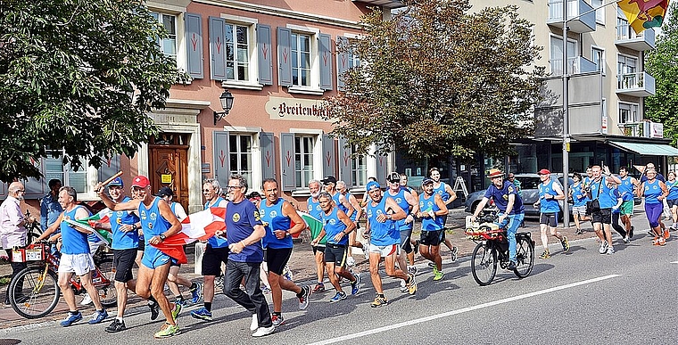 Geschafft: Die 35 Läuferinnen und Läufer aus Artegna und Breitenbach im Zieleinlauf. Vorne in der Mitte die Bürgermeister Dieter Künzli und Aldo Daici. Foto: Roland Bürki