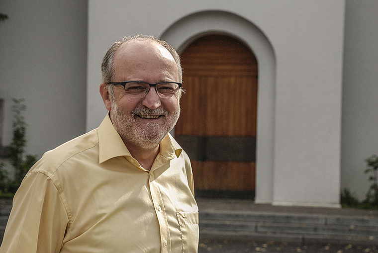 Alois Schuler vor der Kirche St. Nikolaus: «Die Konfessionen sind zusammen eine Familie, in der es wie in jeder Familie auch einmal Auseinandersetzungen gibt.» Foto: Thomas Brunnschweiler