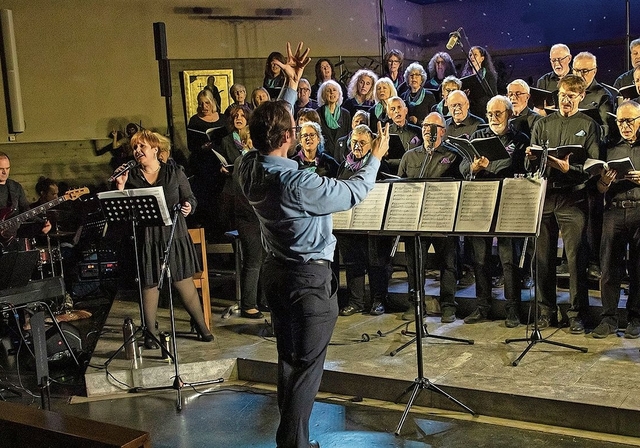 Mit vollem Einsatz: Dirigent Beat Schwerzmann mit Chor, Solistin Fabienne Jäggi und Begleitband. Foto: Martin Staub