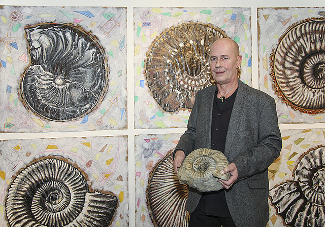 Von Ammoniten umgeben: Norbert Edwin Muspach inmitten seiner Bilder.   Foto: Edmondo Savoldelli