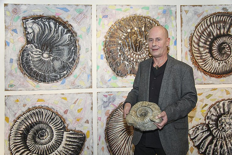 Von Ammoniten umgeben: Norbert Edwin Muspach inmitten seiner Bilder.   Foto: Edmondo Savoldelli