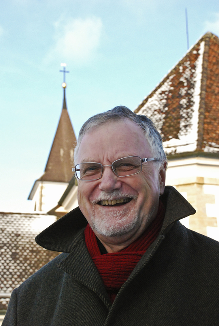 Von einem, der auszog, die Menschen zu lieben: Pfarrer Bernhard Schibli vor der Kirche Aesch. Foto: Thomas Brunnschweiler