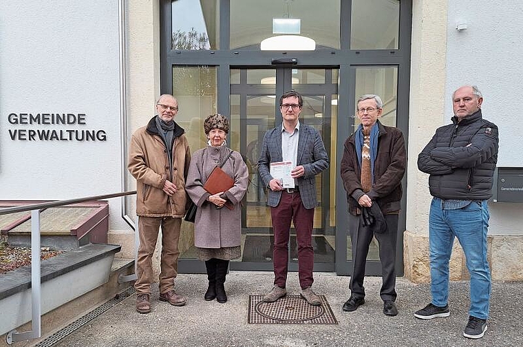 Unterschriften aus der ganzen Welt: Therese Anner (2. v. l.) und weitere Petitionäre übergeben die Petition an Gemeindepräsident Daniel Urech (in der Mitte). Foto: Jeannette Weingartner