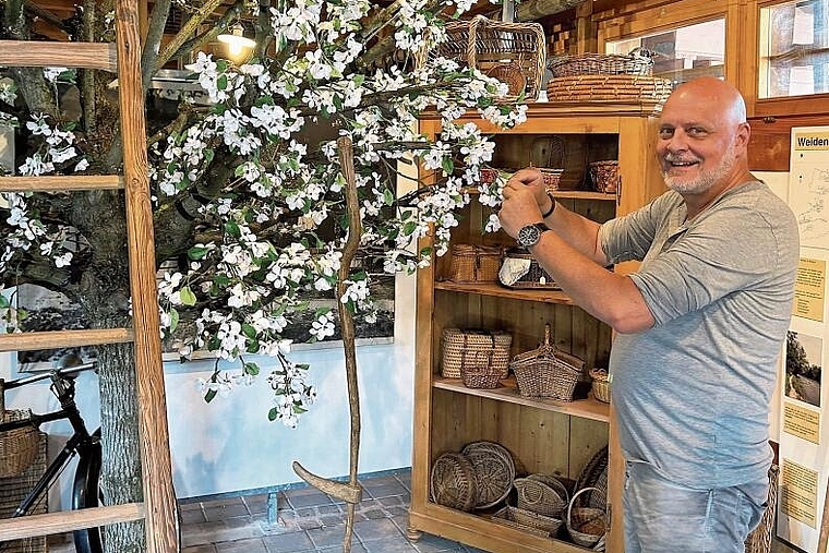 Stolz auf das Geleistete: Mauro Visentin inspiziert die künstlichen Blüten des Baumes in der Remise. Foto: Caspar Reimer