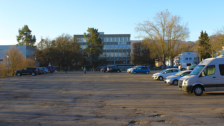 Parkplatz bleibt: Statt neuer Wohnungen werden vor dem Schulhaus Fiechten weiterhin Fahrzeuge zu finden sein. Foto: Caspar Reimer