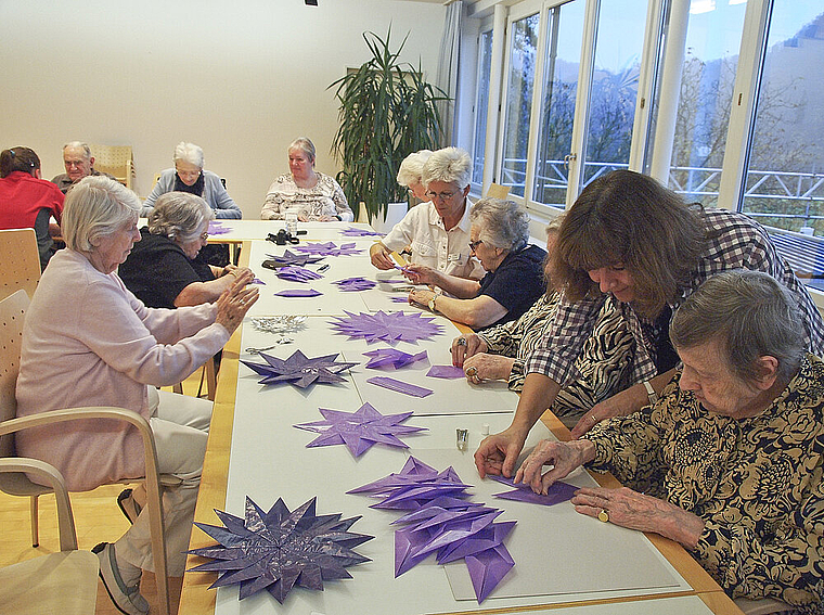 Bastelarbeit zum Fest: Seniorinnen und Senioren des Alters- und Pflegeheims Hofmatt arbeiten am Adventsfenster. Foto: Tobias Gfeller