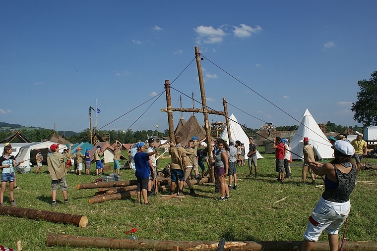 Die Lagerstadt «Narrapolis» entsteht: Mit gemeinsamer Kraft werden für das Küchenzelt Rundhölzer aufgestellt. Foto: Thomas Gschwind