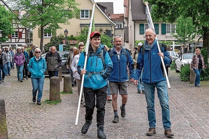 Die Spitze der Banntagsrotte in Arlesheim: Waldchef Thomas Hagen (r.) und Moritz (l.) tragen beim Abmarsch an der Ermitagestrasse die Fahnen, gleich dahinter Bürgerrat Jürg Dünner (M.) Foto: Heiner Leuthardt