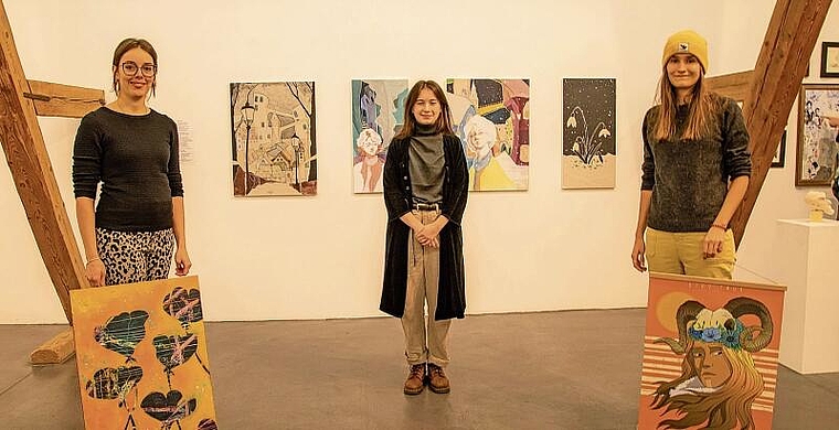 Die drei Talente: Désirée Moser (l.) und Joëlle Häner (r.) zeigen sich mit einem ihrer Bilder mit Magda Lutz und deren Maturaarbeit «Il Neige» im Hintergrund. Foto: Martin Staub