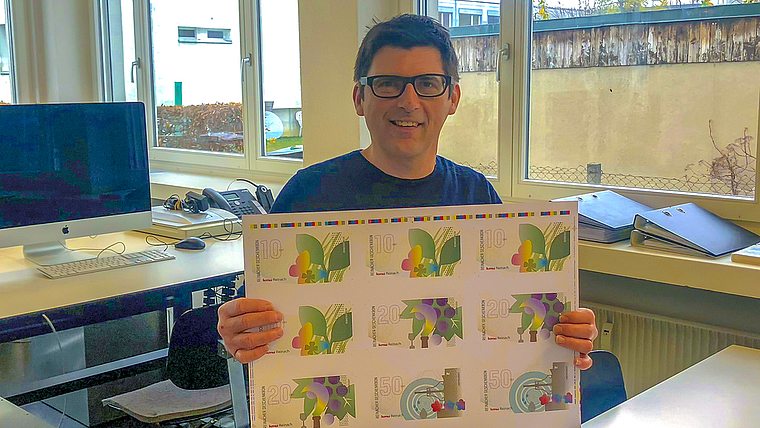 Lokalwährung: Grafiker Reinhard Hammel hat den neuen Reinacher Geschenkbon gestaltet. Foto: Caspar Reimer