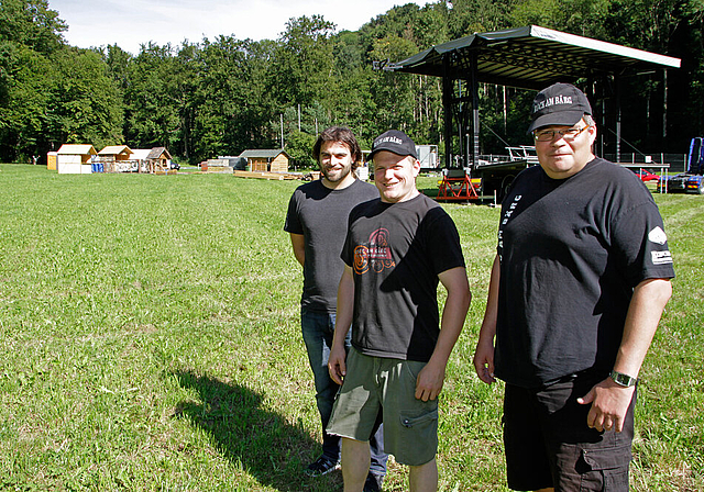 Im Glanz der Sonne: Die Rock-am-Bärg-Verantwortlichen Philippe Garcia, Medienverantwortlicher, Ronny Dobler, Präsident, und Pascal Jeker, Festival-Direktor (v. l.), hier beim Aufbau, hoffen auf gutes Wetter und glauben an einen Erfolg.  Foto: Marti