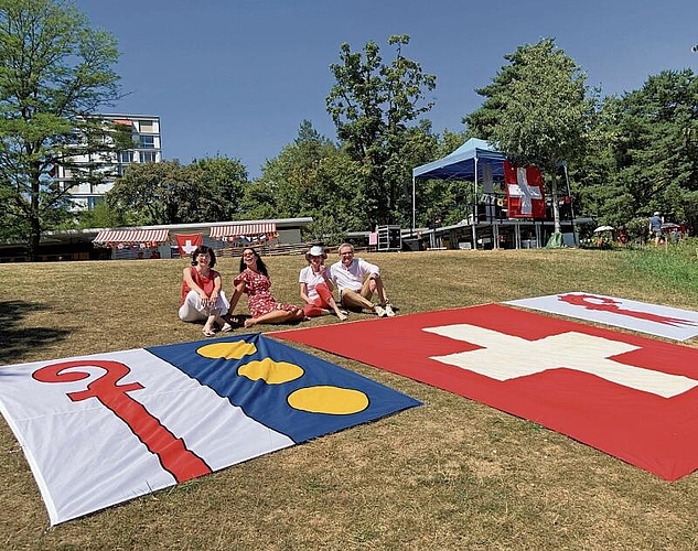 Rot und Weiss dominieren auch hier: Bevor der Gemeinderat ins kühle Nass springt, posiert er vor den Flaggen.