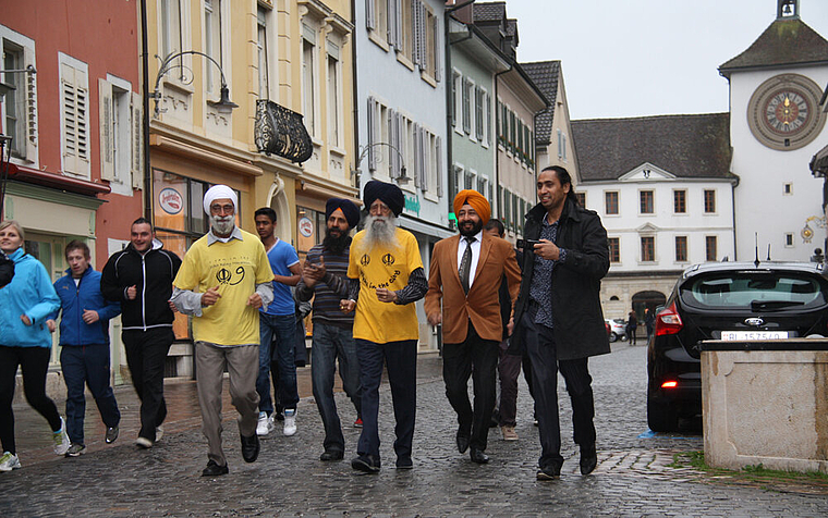 Über hundert und topfit: Fauja Singh, 102 Jahre alt (rechts mit gelbem T-Shirt) joggt durchs Stedtli. Foto: Gaby Walther