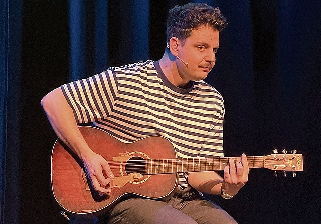 Für einen kurzen Moment an der Gitarre: der Kabarettist Dominik Muheim. Foto: Gaby Walther