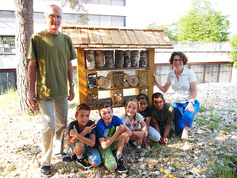 Haben ein «Hotel» für Wildbienen gebaut: Peter Hügin, Nathalie Meyer und Schüler von der Primarschule Aesch. Foto: Tobias Gfeller