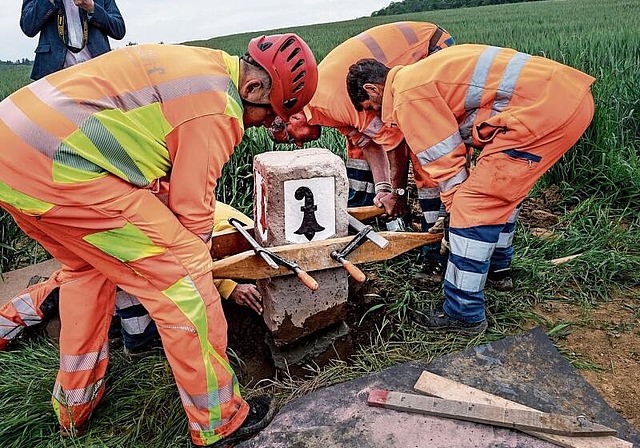 Millimetergenaue Handarbeit: Der besondere Grenzstein Nummer 85 wird platziert. Fotos: Kenneth Nars
