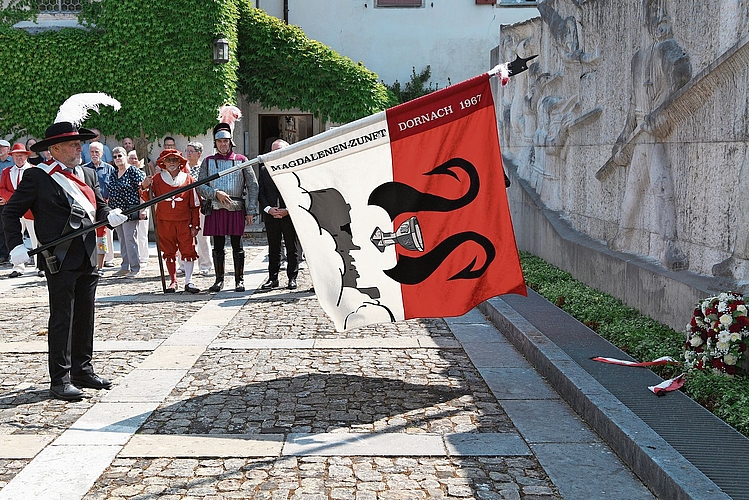 Der Vergangenheit Respekt zollen: Der Fahnenträger der Magdalenen-Zunft schwingt seine Flagge über dem niedergelegten Kranz.Fotos: Juri Junkov