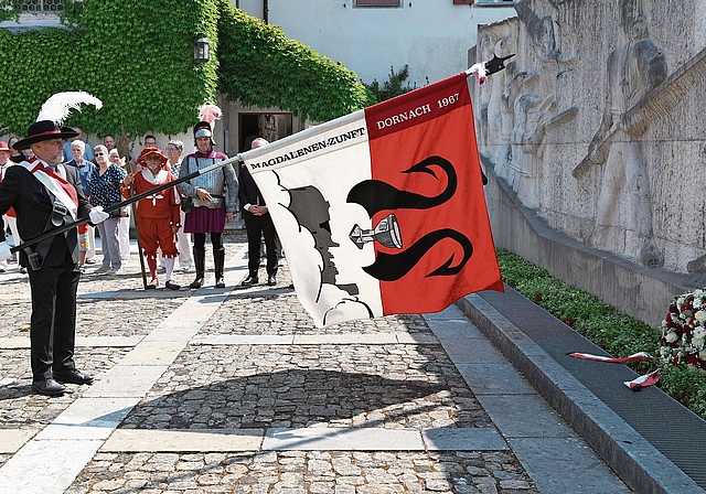 Der Vergangenheit Respekt zollen: Der Fahnenträger der Magdalenen-Zunft schwingt seine Flagge über dem niedergelegten Kranz.Fotos: Juri Junkov