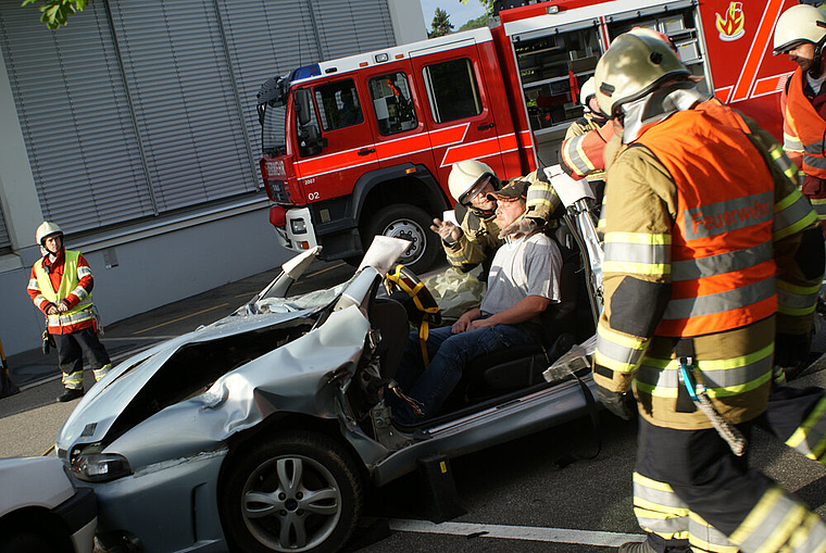 Unfallauto jetzt oben ohne: Der eingeklemmte, aber betreute Fahrer wird befreit. Gut sichtbar die Airbag-Sicherung auf dem Lenkrad. Foto: Roland Bürki