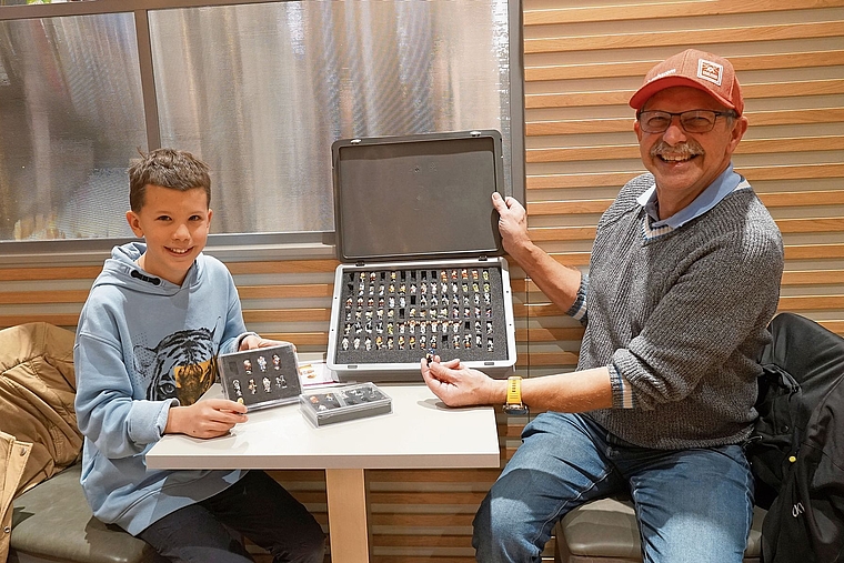 Generationen vereint: Andrin aus Reinach (links) und Kari aus Pfeffingen teilen die Leidenschaft für die Fasnachtsfigürchen. Foto: Tobias Gfeller 