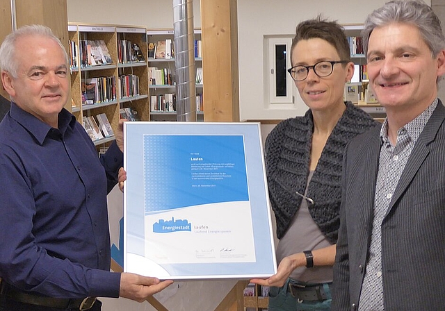 Verpflichtung zu Massnahmen im Energiesektor: Stadträtin Sabine Asprion und Stadtpräsident Alex Imhof nehmen von Felix Jehle, Vertreter der Labelkommission (links), die Urkunde «Energiestadt» entgegen. Foto Thomas Immoos