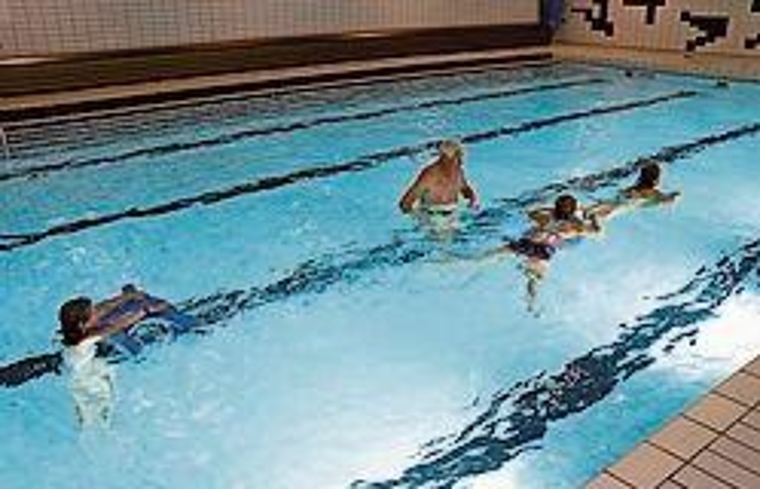 Übung beim Kikkerschwimmen: Georges Götte und drei Kinder mit speziellem Schwimmbrett. Foto: Carlo Lang