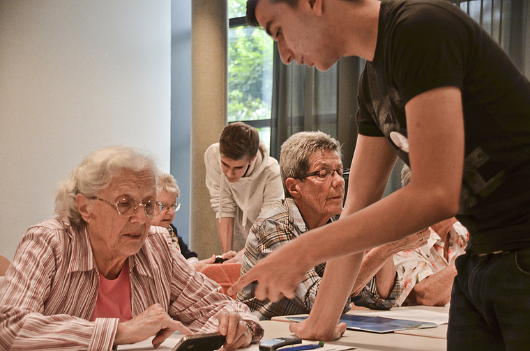 Faszination: Interessiert lässt sich die Seniorin durch den jungen Mann in eine neue Welt ein- bzw. entführen. Foto: Jay Altenbach