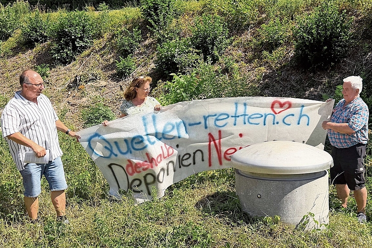 Haben den alten Banner nochmals hervorgeholt: (v. l.) Peter Hueber, Präsident Wasserverbund Birstal (WVB), Gaby Bosshard von der Holinger AG, und Fridolin Scherrer, Burgerpräsident, vor der Quellfassung der Fandelquelle in Zwingen. Als letzte Schut