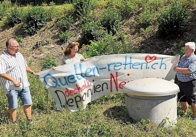 Haben den alten Banner nochmals hervorgeholt: (v. l.) Peter Hueber, Präsident Wasserverbund Birstal (WVB), Gaby Bosshard von der Holinger AG, und Fridolin Scherrer, Burgerpräsident, vor der Quellfassung der Fandelquelle in Zwingen. Als letzte Schut