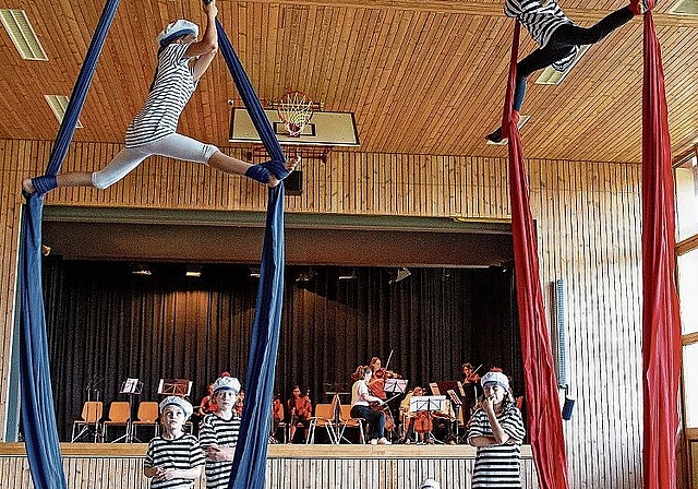 Akrobatik mit Musik: Die Turnenden der Zirkusgruppe FederBlau mit der Schiffskapelle der Musikschule im Hintergrund. Foto: Martin Staub