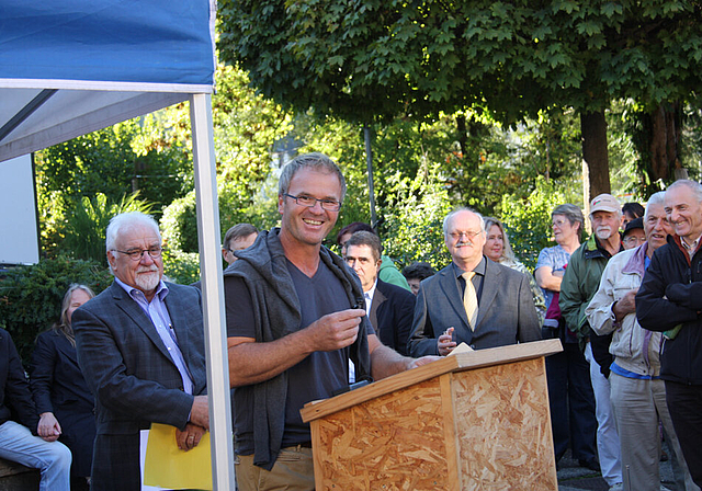Einweihung des Kreisels: Der Künstler Paul Stadler am Rednerpult, links Gemeindepräsident Benno Jermann, rechts Pfarrer Markus Schöbi. Fotos: Gaby Walther
