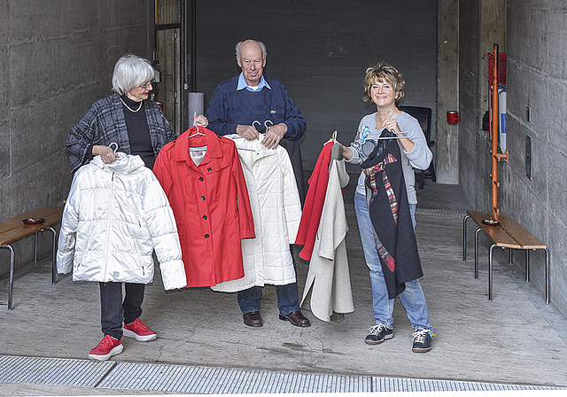 Auf dem Weg in die Zivilschutzanlage: Mitglieder der Begleitgruppe Arlesheim bringen den Flüchtlingen warme Kleidung.  Foto: Bea Asper