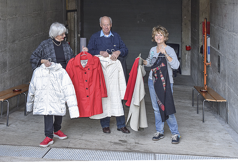 Auf dem Weg in die Zivilschutzanlage: Mitglieder der Begleitgruppe Arlesheim bringen den Flüchtlingen warme Kleidung. Foto: Bea Asper