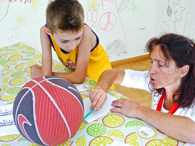 Zusammenarbeit: Der begeisterte Basketballer Denis zeichnet entsprechende Motive auf seinen Button; Treff-Leiterin Patrizia Bernardis gibt ihm dabei Tipps. Foto: Thomas Immoos