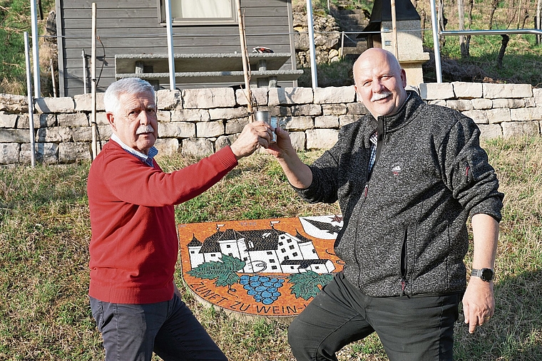Beim zunfteigenen Rebhaus: Zunftmeister Bruno Theiler (links) und Zeremonienmeister Rolf Blatter stossen auf 50 Jahre Zunft zu Wein- und Herbergsleuten Aesch an. Foto: Tobias Gfeller 