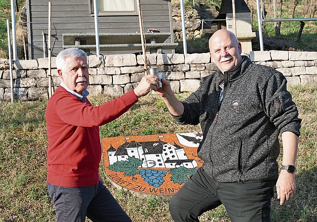 Beim zunfteigenen Rebhaus: Zunftmeister Bruno Theiler (links) und Zeremonienmeister Rolf Blatter stossen auf 50 Jahre Zunft zu Wein- und Herbergsleuten Aesch an. Foto: Tobias Gfeller 