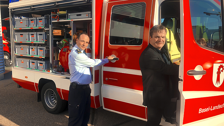 Frisch geliefert: Christoph Wyttenbach, Kommandant der Stützpunktfeuerwehr Reinach (links) und Sven Cattelan, Direktor der Basellandschaftlichen Gebäudeversicherung, besteigen das nagelneue Löschfahrzeug. Foto: Caspar Reimer
