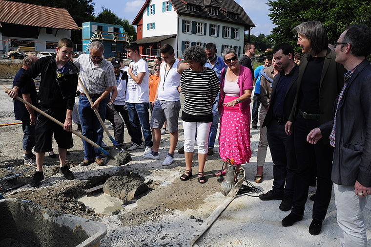 Symbolischer Moment: Eine «goldene» Truhe wird ins Fundament des neuen Werkstattgebäudes eingelassen. Foto: Heiner Leuthardt