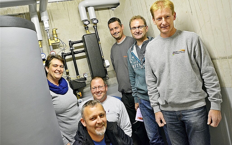 Die Übergabestation an der Wand ersetzt die Heizung: Vorne Martin Bucher (Wärmeverbund); v.l. Petra und Daniel Henz, Markus Perreten (Viessmann), Dominik und Daniel Hügli (Wärmeverbund) Foto: Roland Bürki