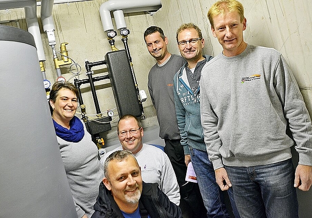 Die Übergabestation an der Wand ersetzt die Heizung: Vorne Martin Bucher (Wärmeverbund); v.l. Petra und Daniel Henz, Markus Perreten (Viessmann), Dominik und Daniel Hügli (Wärmeverbund) Foto: Roland Bürki