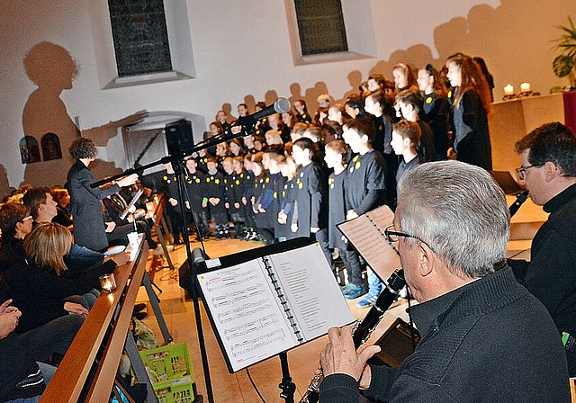Im Sternenlicht: Rund 80 Schulkinder singen unter Leitung von Musiklehrerin Natalia Hofer. Paul Stebler, Erzähler/Klarinette (vorne), sowie Daniel Inglin, Klarinette, und verdeckt Sebastian Schmid am Schlagzeug. Foto: Roland Bürki