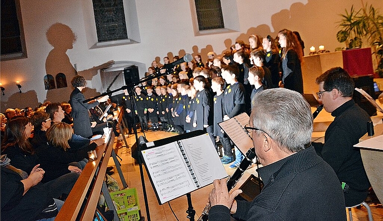 Im Sternenlicht: Rund 80 Schulkinder singen unter Leitung von Musiklehrerin Natalia Hofer. Paul Stebler, Erzähler/Klarinette (vorne), sowie Daniel Inglin, Klarinette, und verdeckt Sebastian Schmid am Schlagzeug. Foto: Roland Bürki