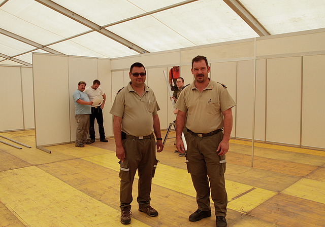 Die Heinzelmännchen der AGLAT 14: Patrick Kleiber, Kommandant ZIKOLA (r.), Thomas Christ, sein Stellvertreter, und fleissige Mitarbeiter beim Standaufbau im Hintergrund.  Foto: Martin Staub